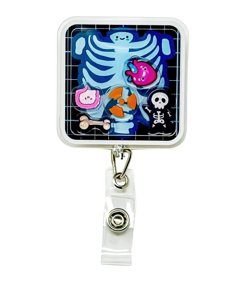 Radiant Ray shaker badge reel by Papaya Pals, showcasing a vibrant sun-themed design with sparkling shaker elements inside a clear casing, ideal for brightening up your workday with a touch of sunshine.